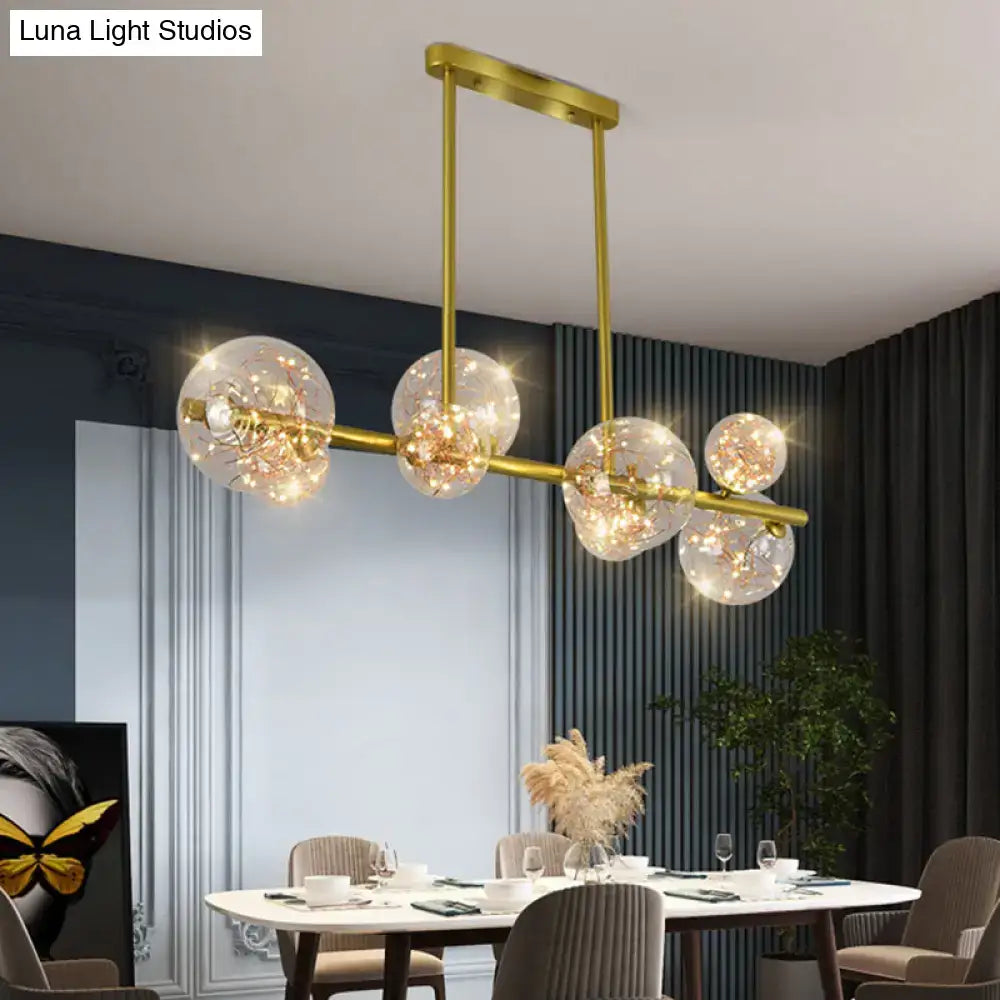 Modern gold spherical clear glass chandelier light fixture with five clear glass spheres housing warm led lights