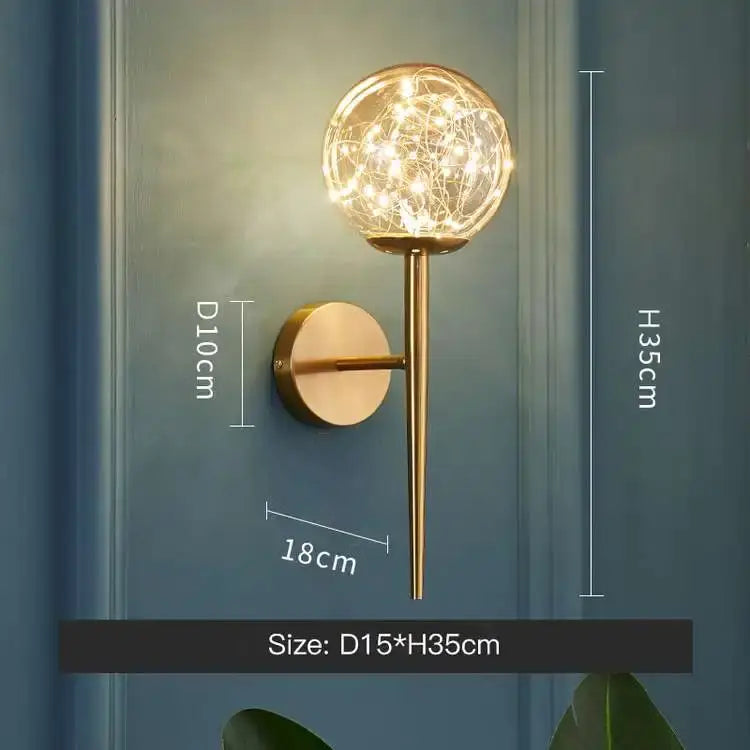 Modern gold star glass pendant light featuring a gold-toned wall sconce with a spherical glass globe and string lights
