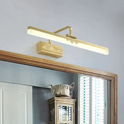Gold-finished modern wall sconce with swing arm and tube metallic wall design featuring engraved mountain motif