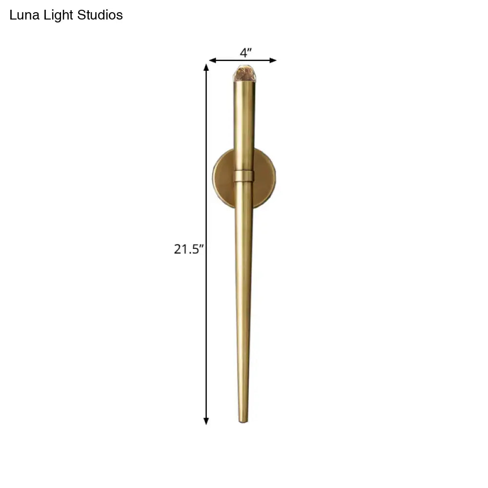 A sleek 21.5-inch tall modern gold tapered brass wall lamp for living room lighting with a textured crystal cap