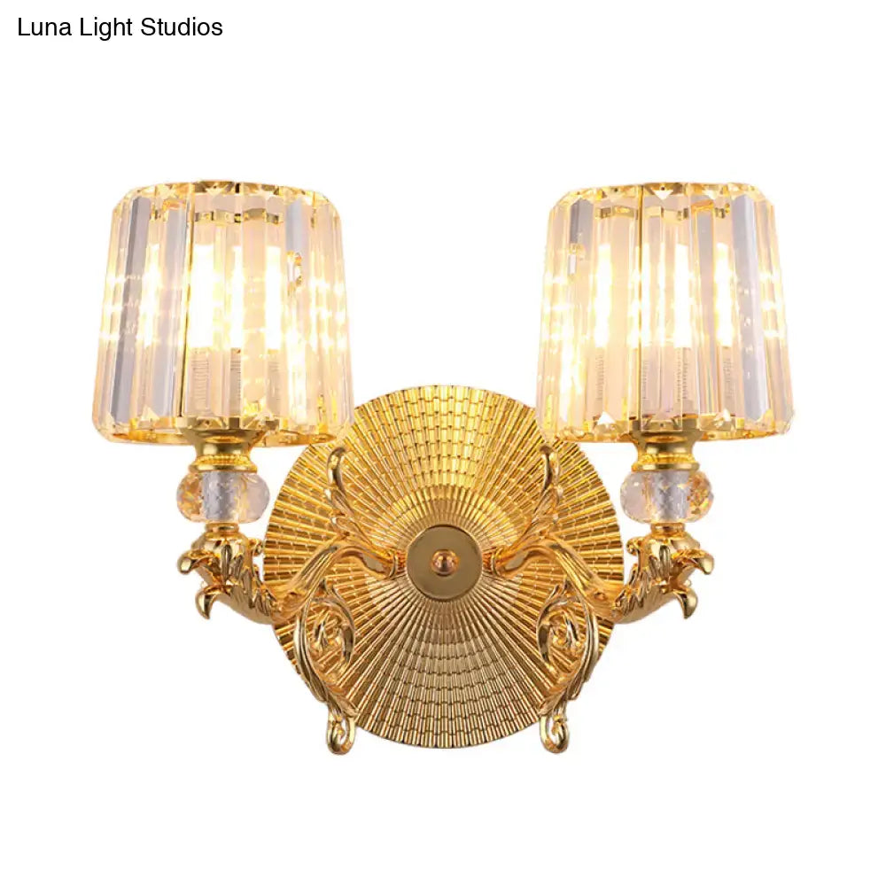 Modern gold tapered wall light fixture featuring a gold-finished ornate design with two crystal-encased lights
