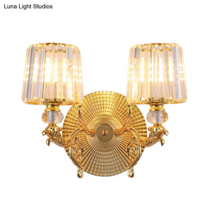 Modern gold tapered wall light fixture featuring a gold-finished ornate design with two crystal-encased lights