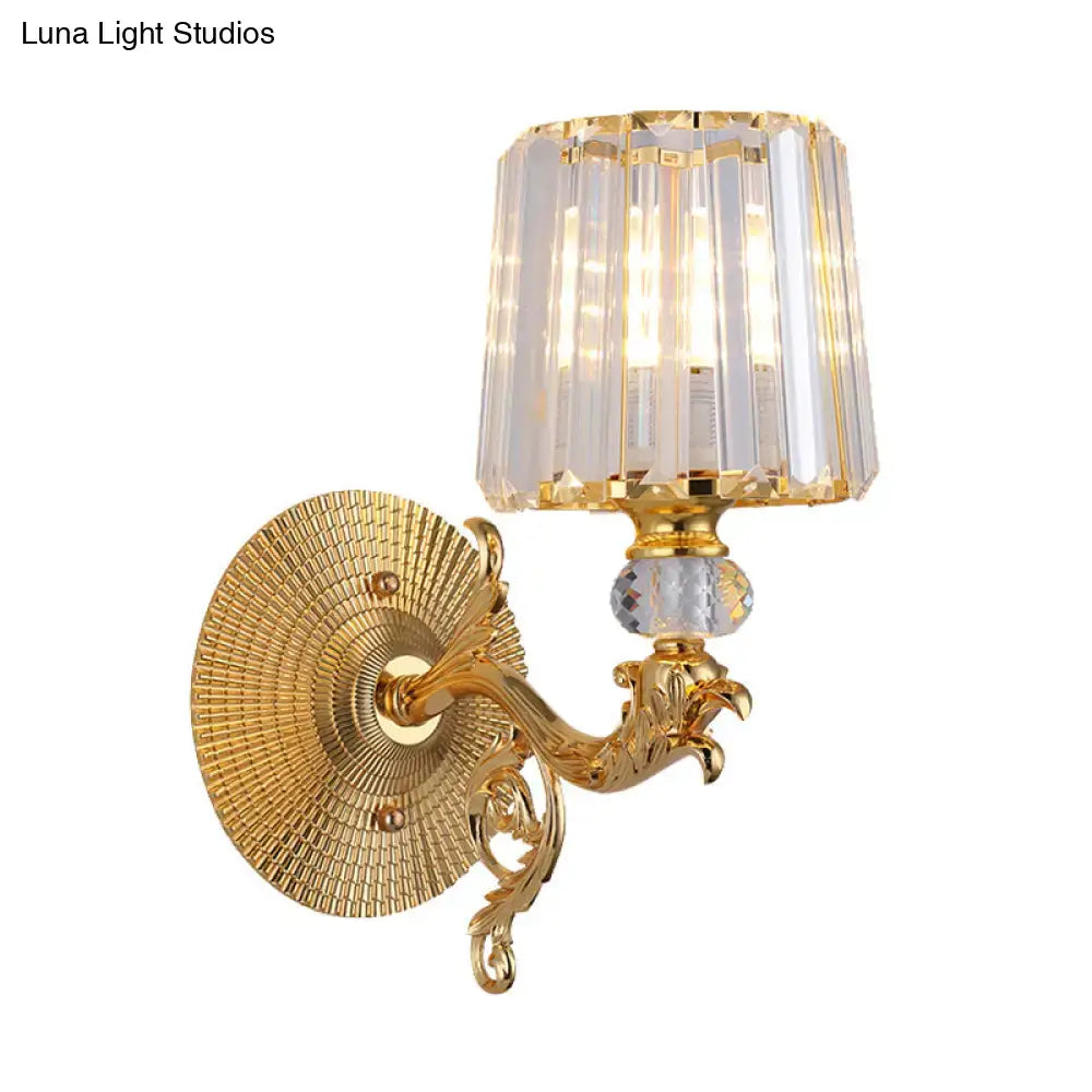 Modern gold tapered wall light fixture with gold finish ornate scrollwork arm and faceted crystal shade bedroom sconce