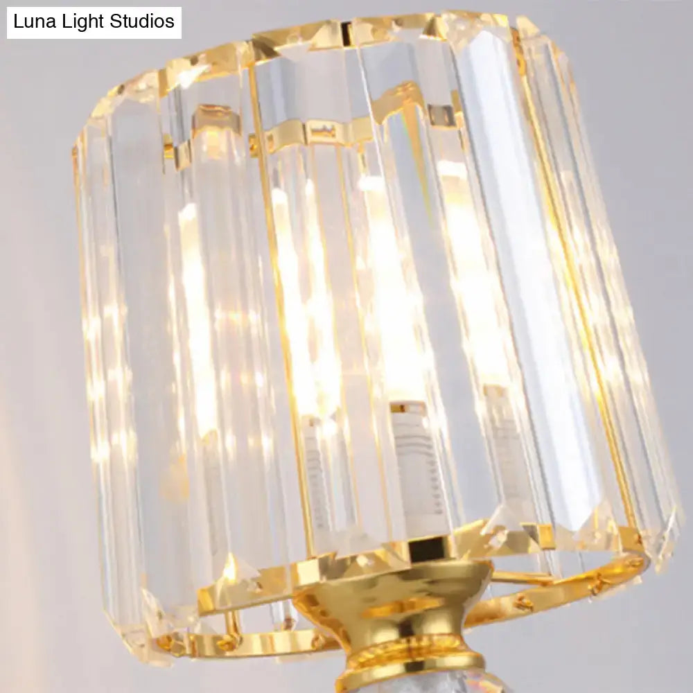 Modern gold tapered wall light fixture featuring a golden-framed crystal chandelier with faceted glass rods