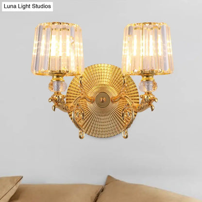 Modern gold tapered wall light fixture with ornate gold finish and two crystal-fringed lampshades for bedroom use