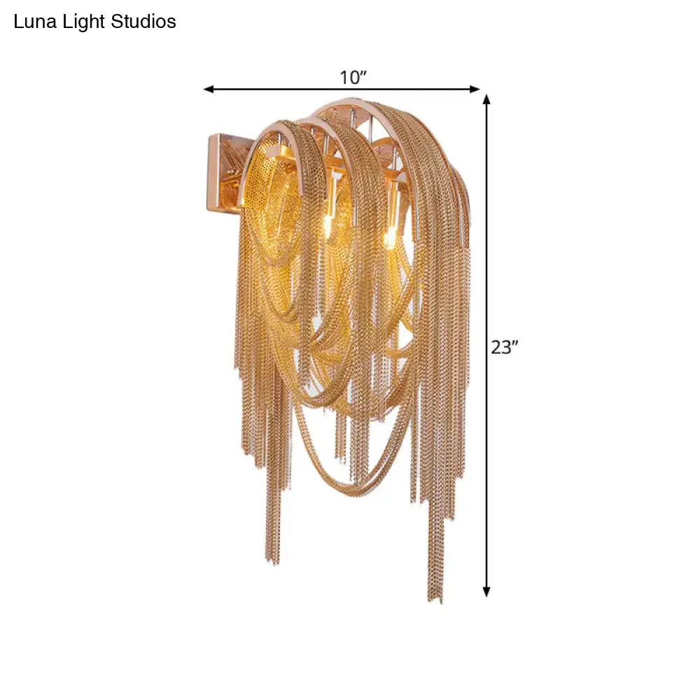 Modern gold tassel wall sconce featuring gold-toned cascading chains and rectangular mounting plate for 110v-120v use