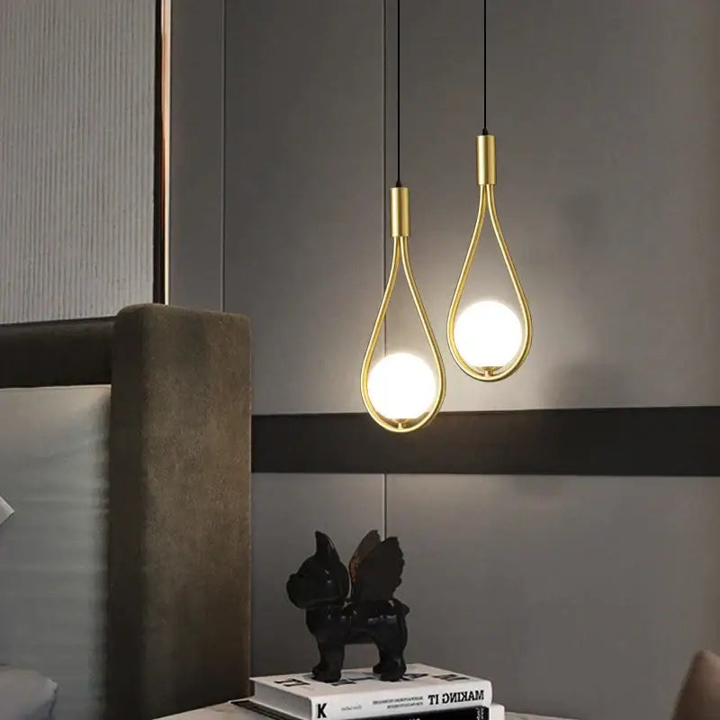 Two elegant gold-toned decorbites glass ball pendant lights with teardrop frames for modern kitchen decor