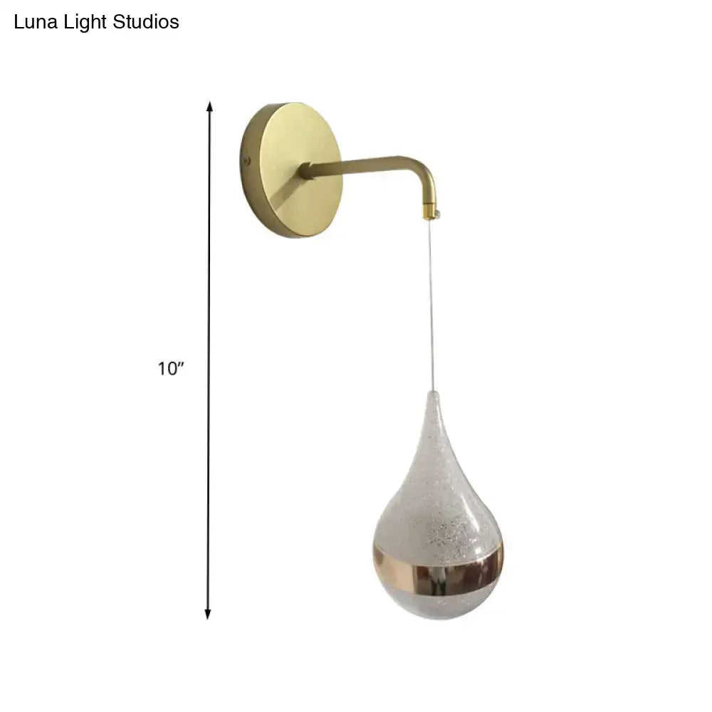 A sleek brass-finished modern gold teardrop wall sconce with frosted glass shade direct wired electric light for bedroom