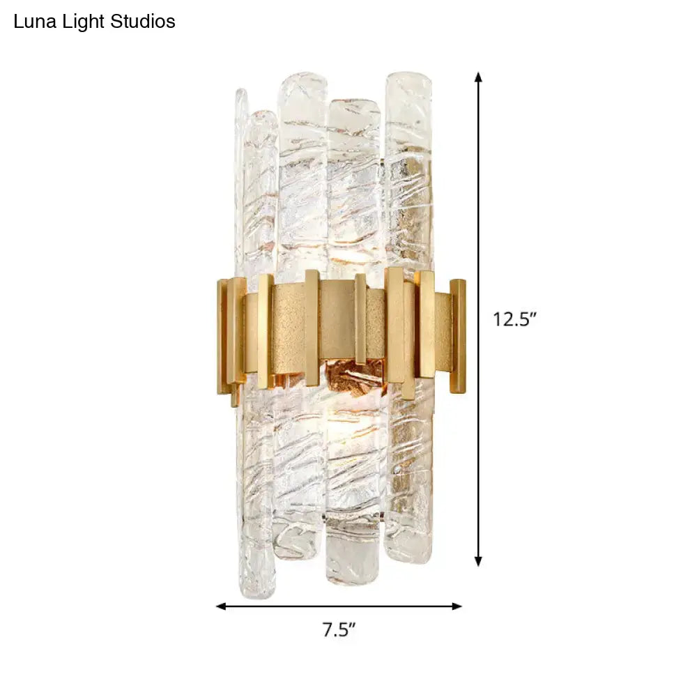 Modern gold textured glass sconce light fixture featuring clear glass rods in a gold-toned metal frame for bedroom use