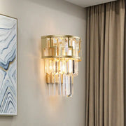 Modern gold tiered bedside wall lamp with geometric metal frame and cascading clear crystal prisms for bedroom use