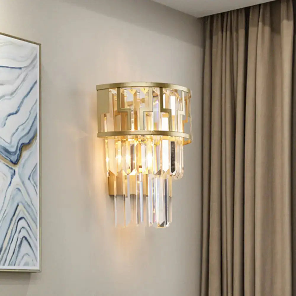 Modern gold tiered bedside wall lamp with geometric metal frame and cascading clear crystal prisms for bedroom use