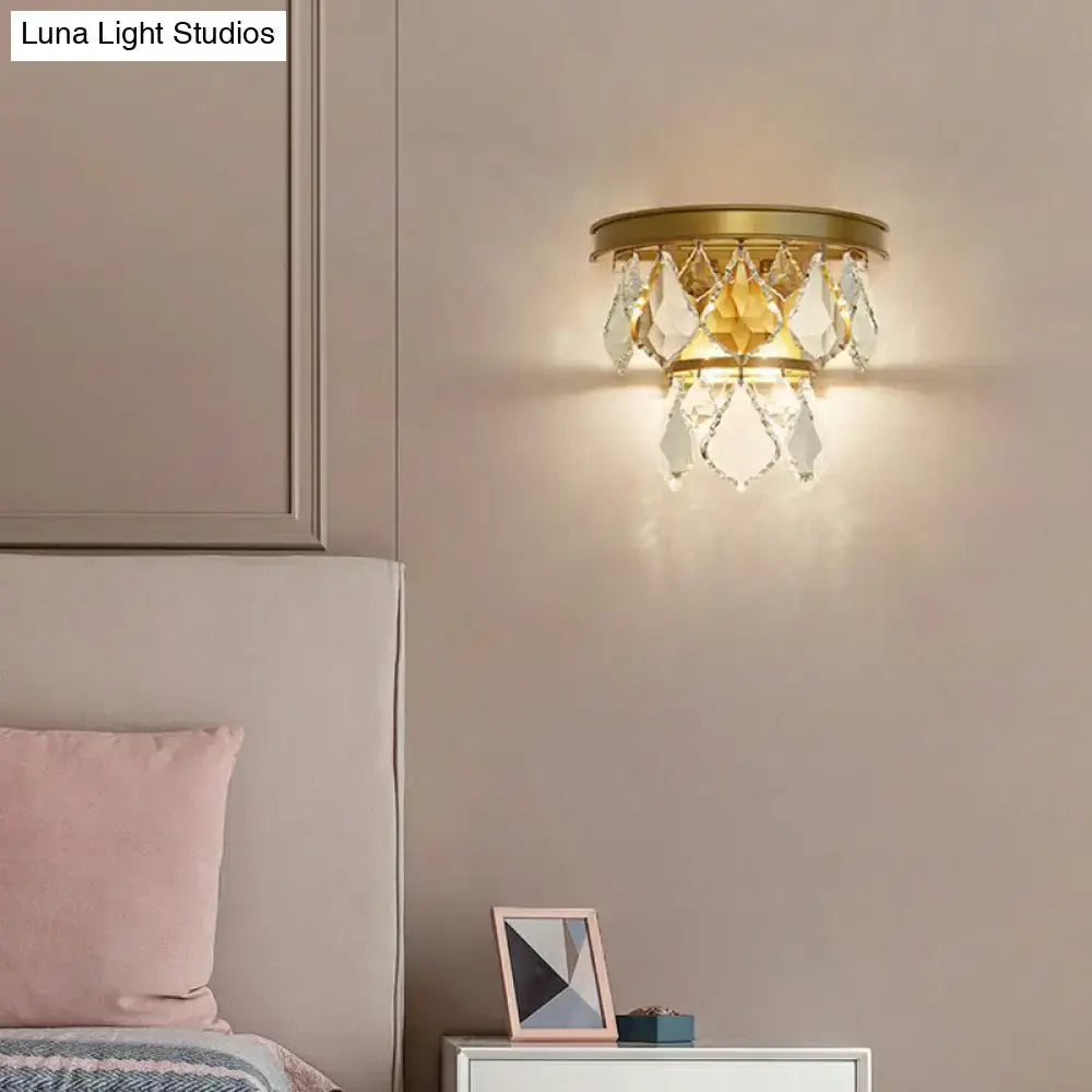 Modern gold tiered sconce light fixture with dangling clear crystals for bedside wall mount in bedroom decor