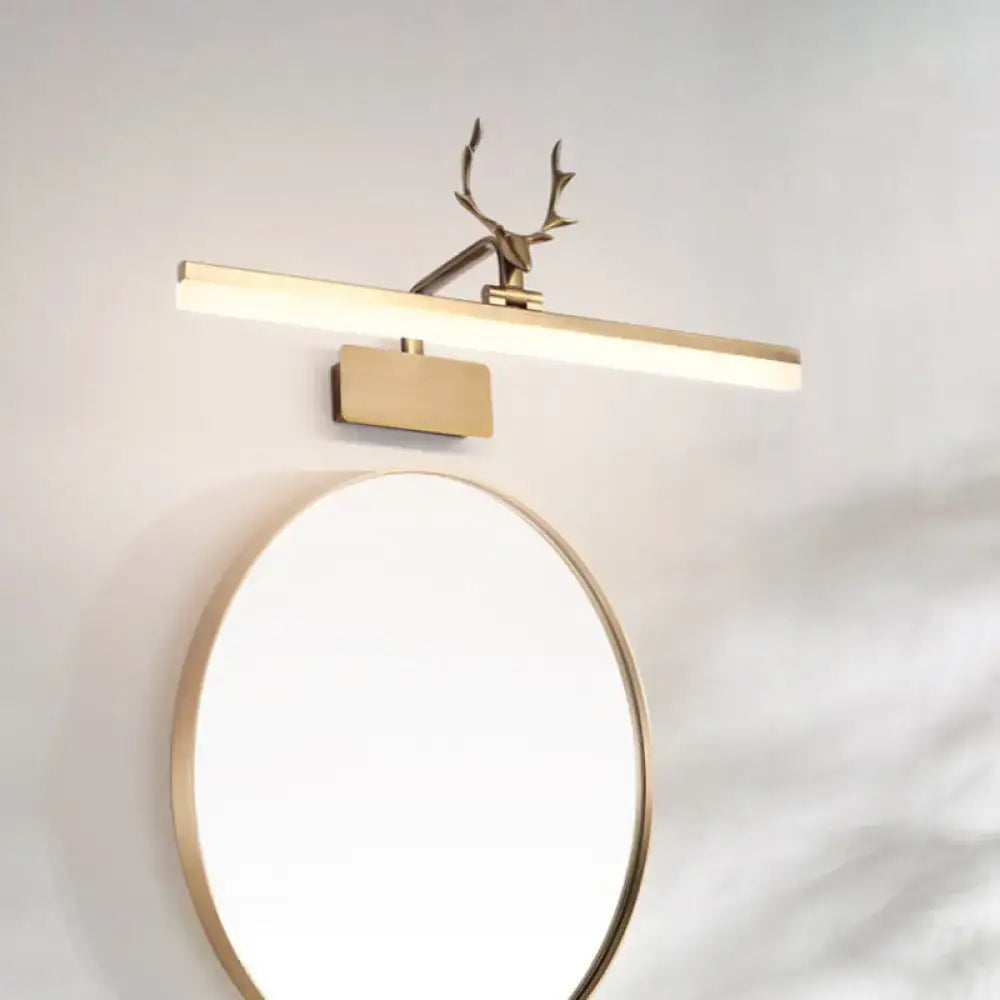Modern gold tubular antler led vanity light fixture with deer head finial above matching round bathroom mirror light fixture