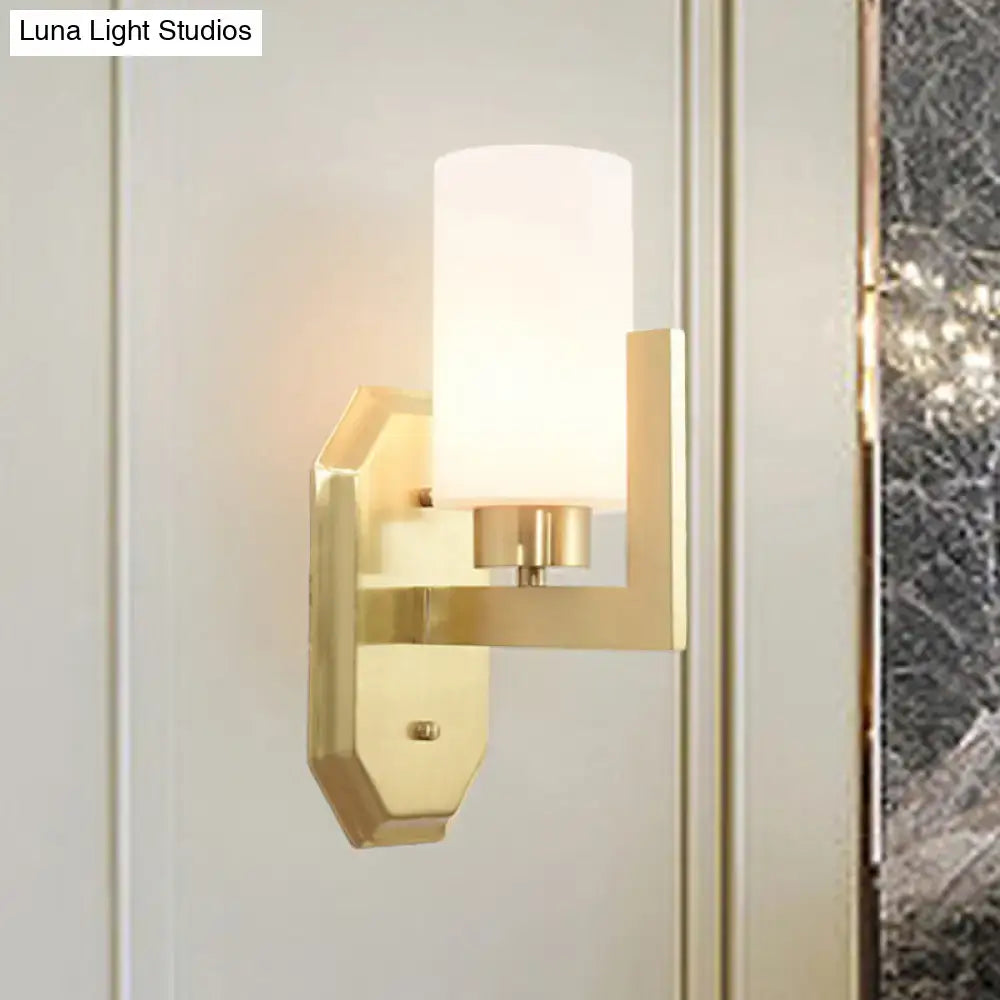 Modern gold tubular wall lamp with frosted glass cylinder shade is a stylish living room product fixture