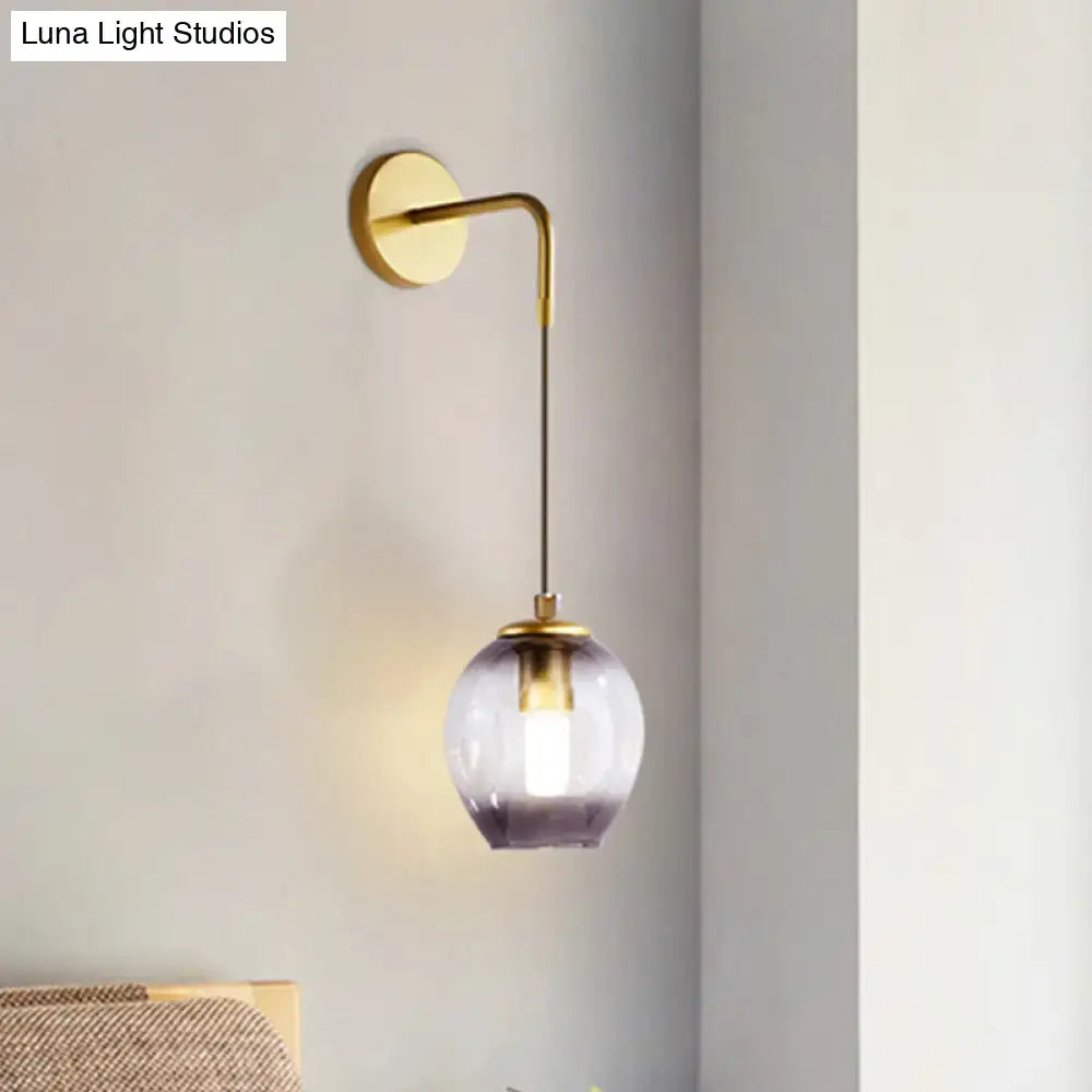 Modern gold tulip wall lamp with a brass finish and a spherical glass shade fading from clear to deep purple