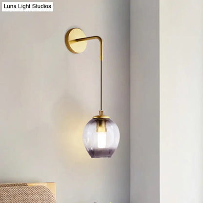 Modern gold tulip wall lamp with a brass finish and a spherical glass shade fading from clear to deep purple