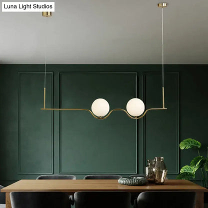 Modern gold two head pendant light with frosted glass shade and brass bulb base for dining room illumination