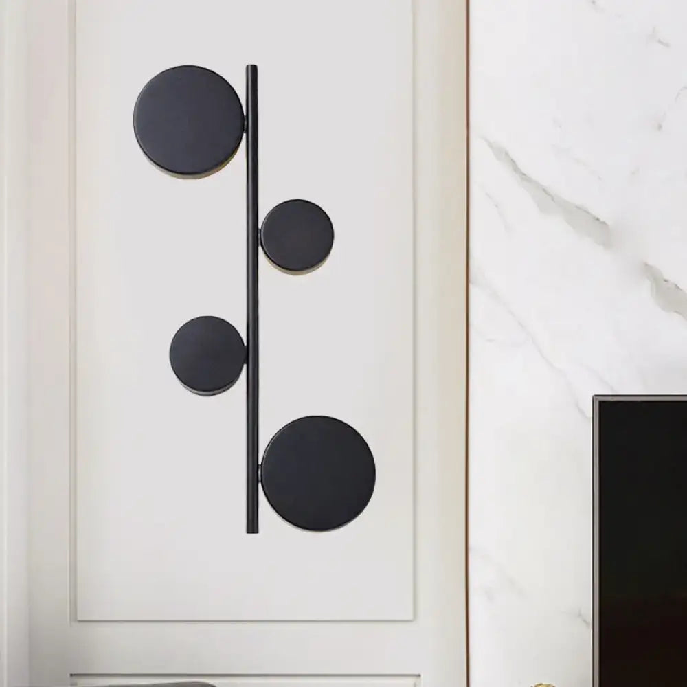 Black gold finish modern vertical linear sconce light with four circular discs on a slender rod for living room