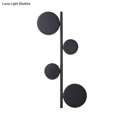 Modern black matte-finished vertical linear sconce light with four circular discs for living room wall decor in black gold finish