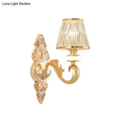 Gold wall sconce lamp fixture with ornate gold finish and faceted crystal cone shade for bedroom lighting