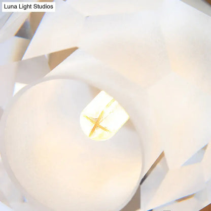 Modern gold wall lamp with faceted globe shade featuring a white geometric paper lantern and glowing light bulb center