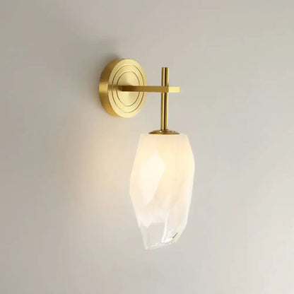 Modern gold wall lamp with frosted glass shade featuring a faceted translucent design for bedroom lighting