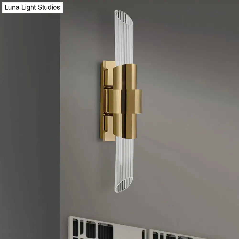 Modern gold wall lamp with sleek curved glass diffuser and vertical ridged prismatic crystal shade for bedroom use