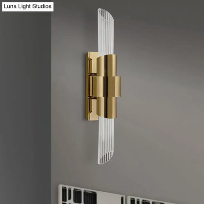 Modern gold wall lamp with sleek curved glass diffuser and vertical ridged prismatic crystal shade for bedroom use
