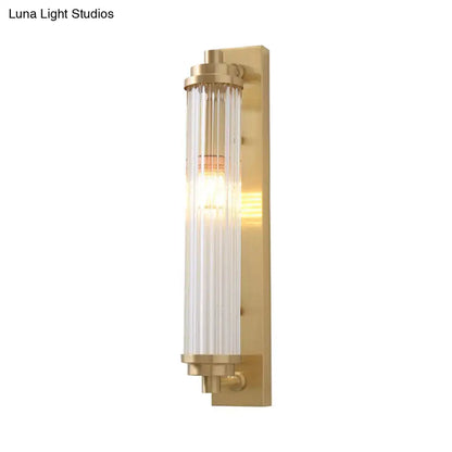Modern gold brass-finished wall light fixture with vertical frosted glass panels and warm bulb, direct wired electric 220v-240v