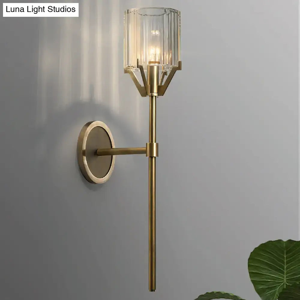 Modern gold wall light with brass finish and clear crystal block cylinder shade for elegant bedroom lighting
