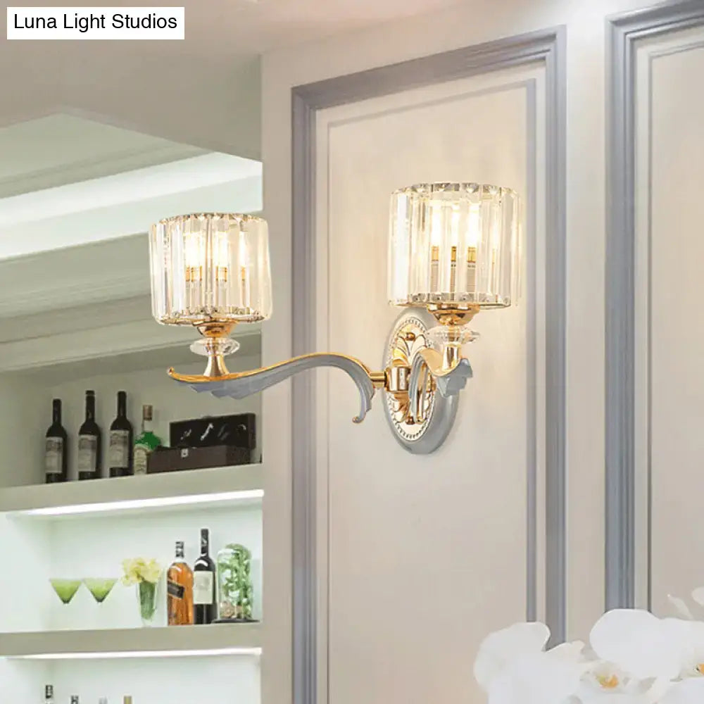 Modern gold wall light with clear crystal shade and two crystal-encased fixtures on a curved ornate arm for living room use