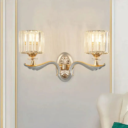 Modern gold wall light featuring two silver arms and clear crystal shade for elegant living room lighting