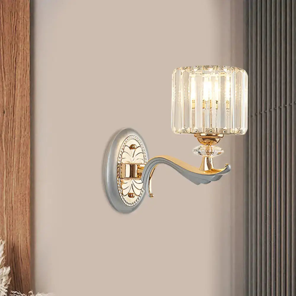 Elegant modern gold wall light with clear crystal shade featuring vertical prisms and decorative backplate for living room