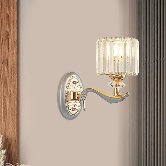 Elegant modern gold wall light with clear crystal shade featuring vertical prisms and decorative backplate for living room