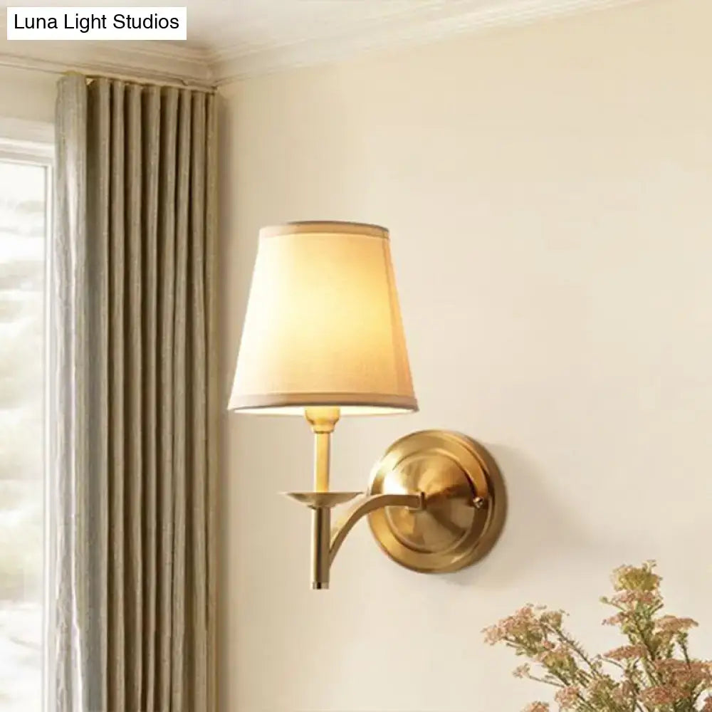 Brass wall light with fabric shade and beige lampshade featuring modern gold finish and compact fixture width for bedrooms