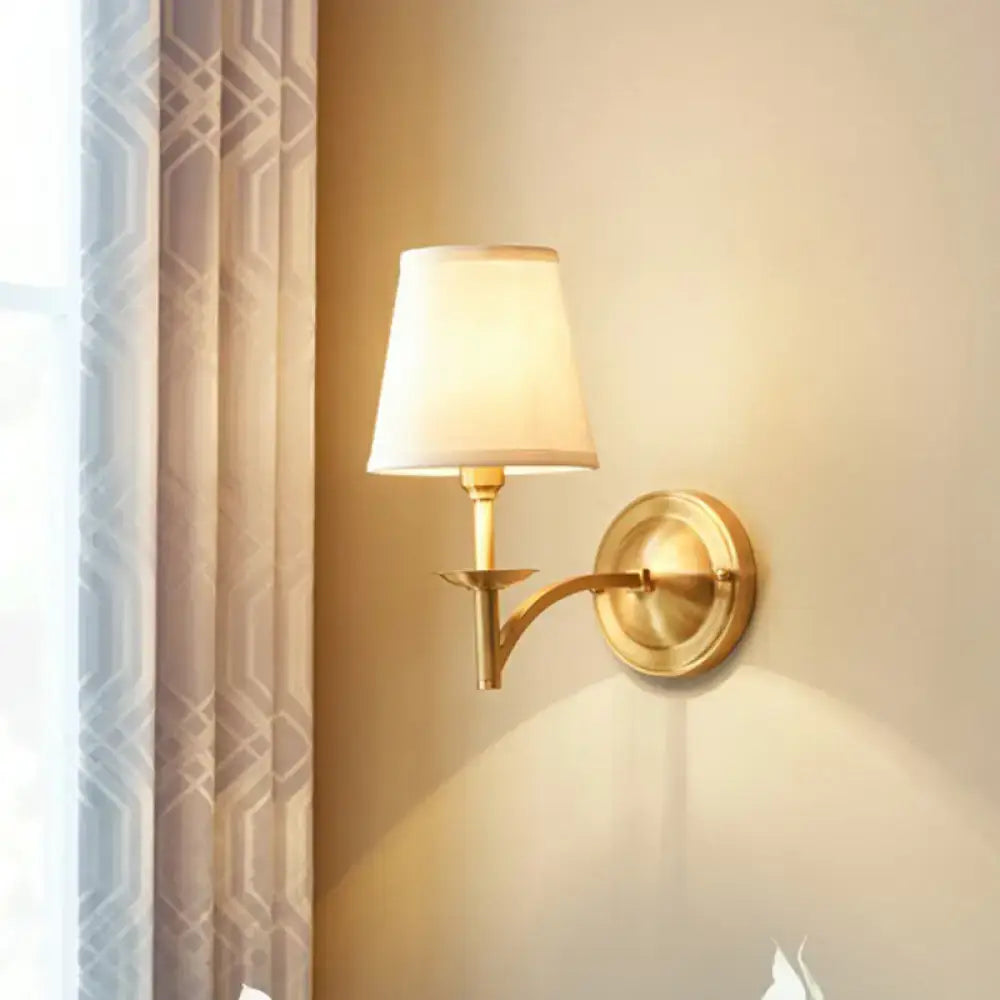 Modern gold wall light with fabric shade featuring a gold-toned fixture and cream-colored fabric shade for bedrooms