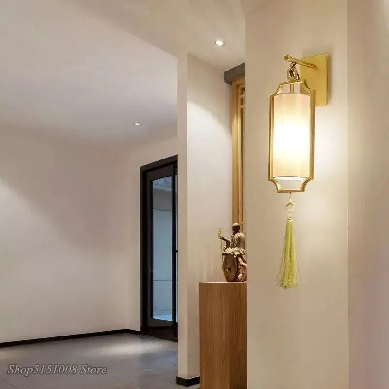 Modern gold wall lights with a tassel shade featuring a gold frame, beige fabric, and pale green tassel for living room decorbites copper wall lights