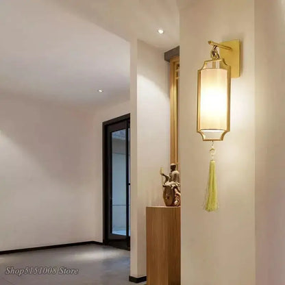 Modern gold wall lights with a tassel shade featuring a gold frame, beige fabric, and pale green tassel for living room decorbites copper wall lights