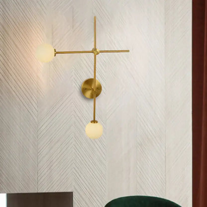 Modern gold wall mount lamp with closed glass globes and crossed wall mount design for living room lighting