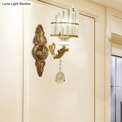 Gold wall mount arc sconce with ornate design crystal accents and dangling decorative pendant for bedroom use