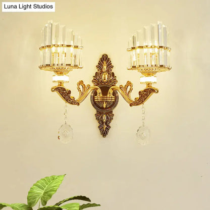 Modern gold wall mount light arc sconce with two crystal chandelier arms and dangling clear crystals for bedroom