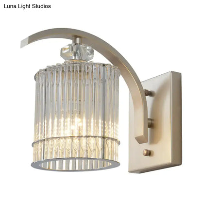A sleek brushed nickel wall mounted lamp with a curved arm and clear crystal shade for bedroom sconce lighting
