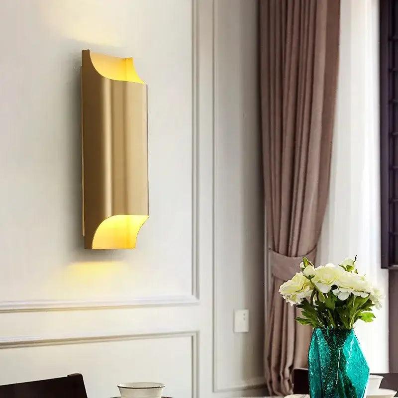 Modern gold wall sconce with sleek curved design and warm ambient lighting for living room decorbites copper brass wall lamp
