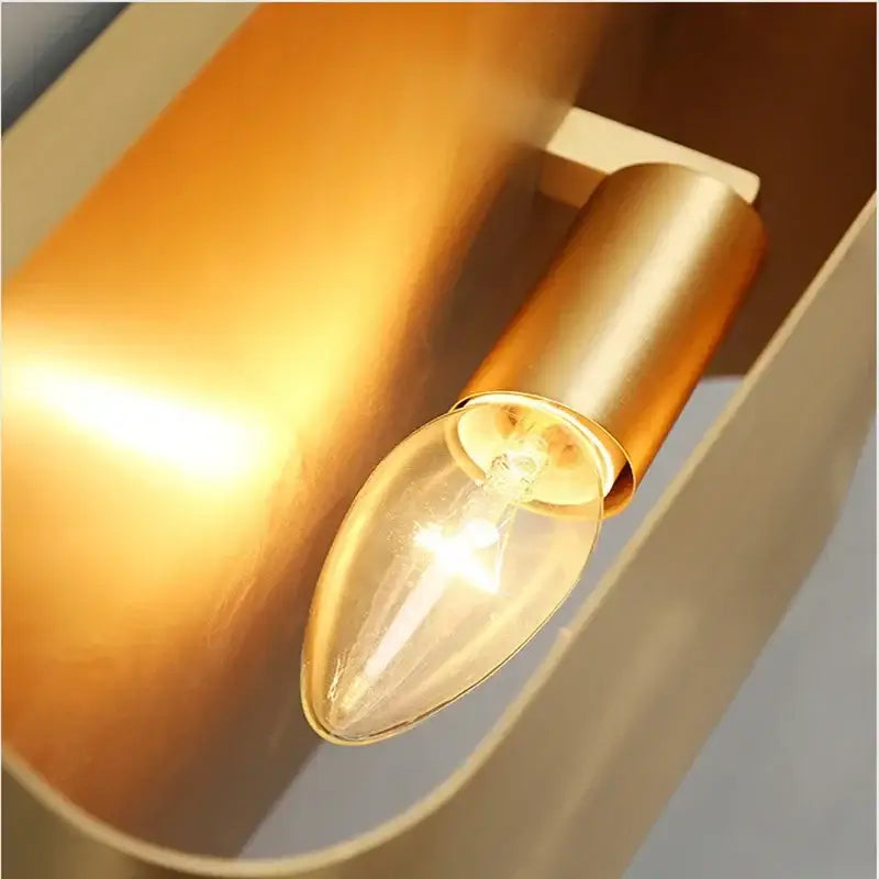 Modern gold wall sconce with warm-toned brushed brass and clear glass bulb ideal as a minimalist living room wall lamp decorbites copper brass