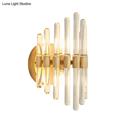 Modern gold wall sconce with clear crystal tubes and brass accents perfect for elegant living room lighting
