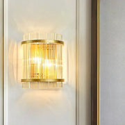 Modern gold wall sconce featuring vertical clear crystal rods designed for elegant hallway lighting
