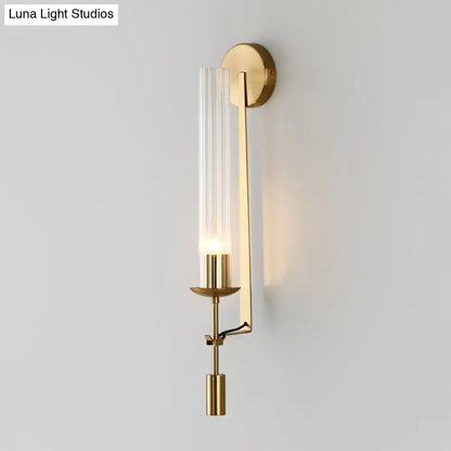 Modern gold wall sconce with clear glass shade featuring a gold-toned finish and sleek metallic accents for bathroom light