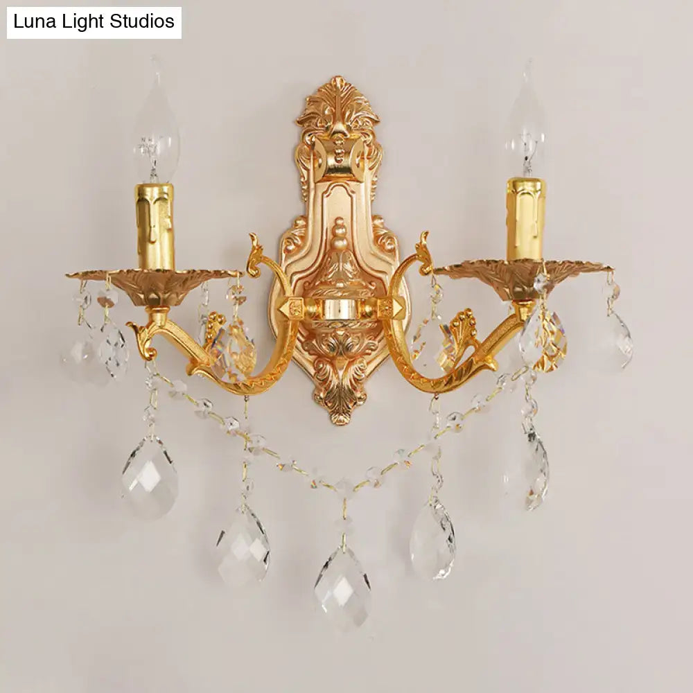 Modern gold wall sconce with crystal drops features two candle-style e12 e14 arms for elegant bedroom lighting