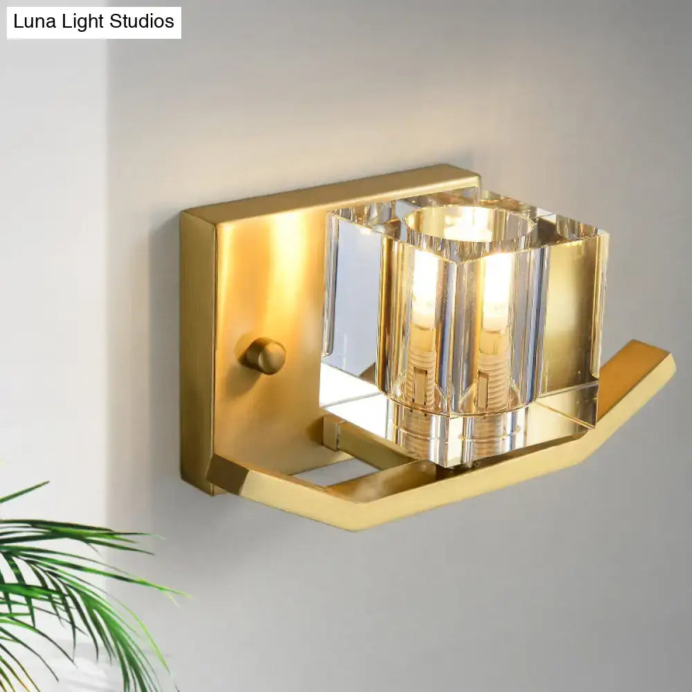 Modern gold wall sconce featuring a cubic clear crystal faceted shade for elegant parlor lighting