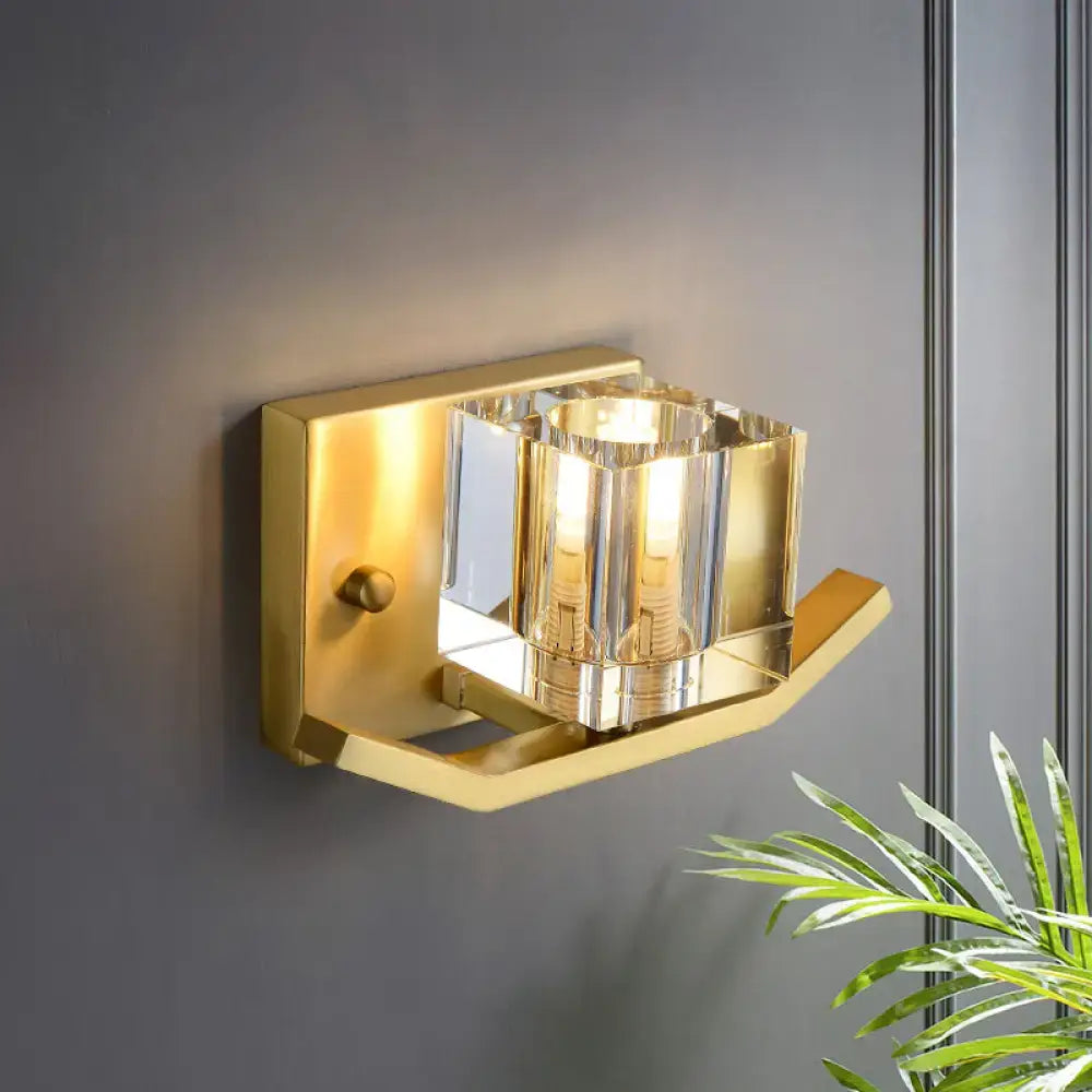 Modern gold wall sconce with cubic clear crystal faceted glass shade and polished metal frame for parlor lighting